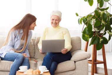 Gülmek anne ve kız izlerken videolar üzerinde laptop