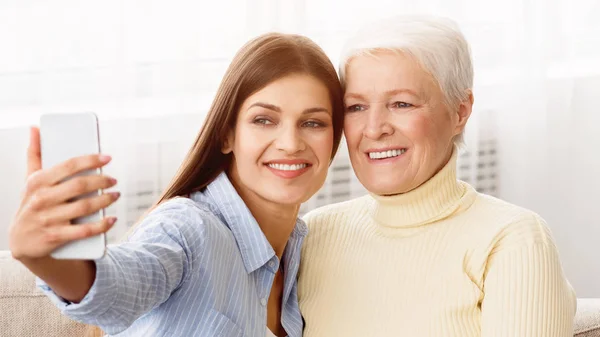 Selfie med mor. Datter tager foto med mor - Stock-foto