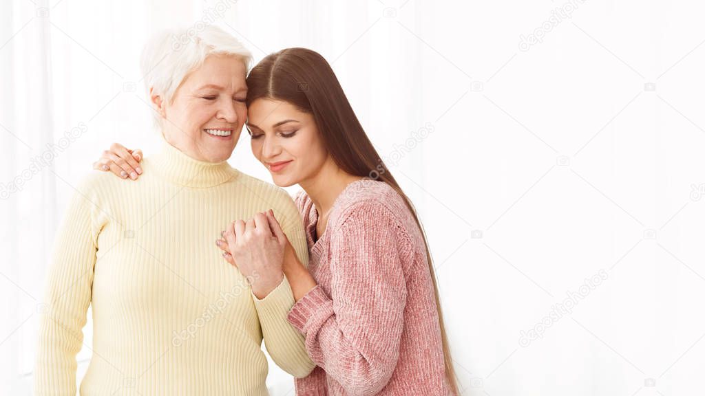 Loving woman embracing mum, posing for family photo