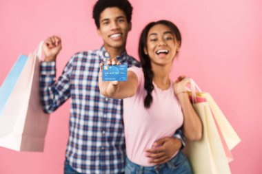 Alışveriş çantaları ve kredi kartı ile mutlu genç çift
