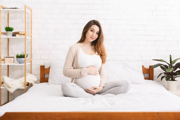 Hamile kadın enjoting gebelik yatak odasında — Stok fotoğraf