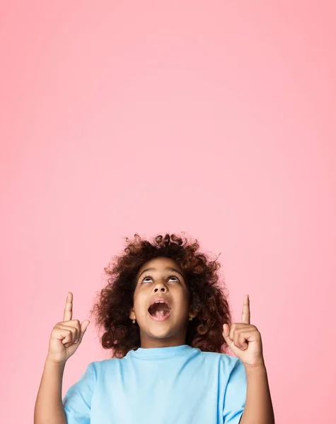 African-american girl pointing fingers up on copy space — Stock Photo, Image