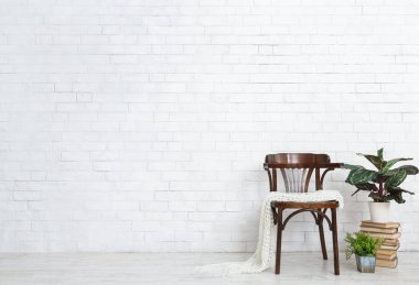 Vintage sandalye, ev bitkileri ve yerde kitap yığını