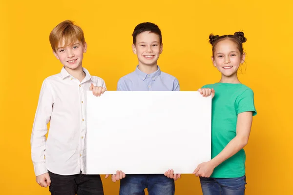 Счастливые дети держат плакат для рекламы — стоковое фото