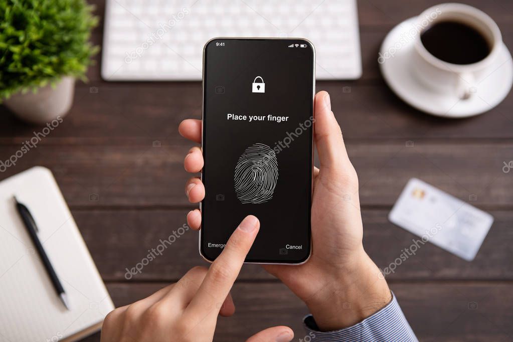Hand holding mobile phone with application for scanning fingerprint