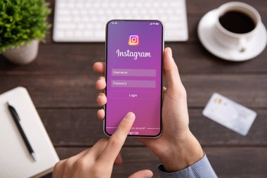 İPhone ack Instagram uygulama ile ekranda tutan adam.