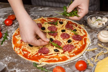 Pizza yemek. Kadın roket salata pizza için ekleme