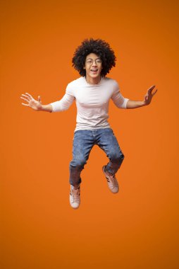 Neşeli Afro-Amerikan kıvırcık adam havada atlama