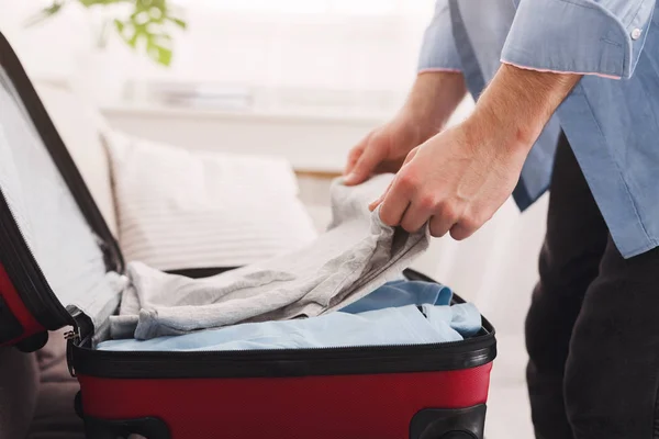 若い男が、クローズ アップのベッドにスーツケースをパッキング — ストック写真