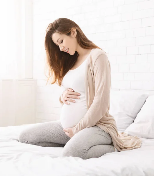 Gravid kvinna enjoting graviditet i hennes sovrum — Stockfoto