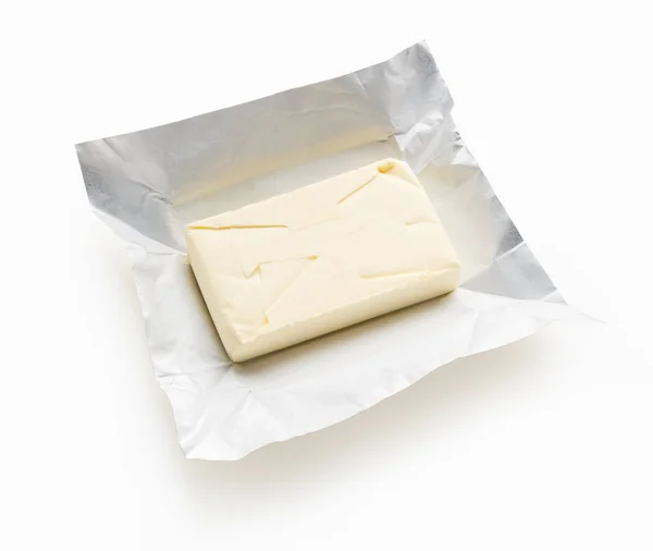 Pezzo di burro su fondo bianco — Foto Stock