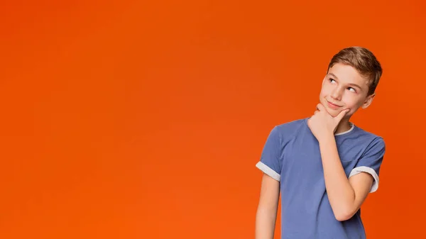 Pensive koulupoika ajatellut jotain oranssi — kuvapankkivalokuva
