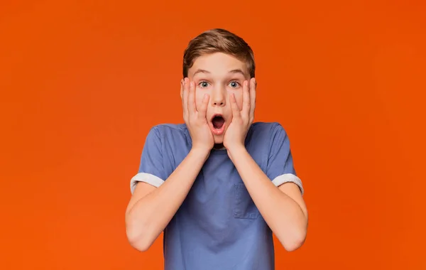 Shocked niño mantener la boca abierta y tocar la cara —  Fotos de Stock