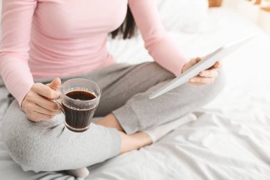 Genç kadın yatakta dijital tablet kullanma