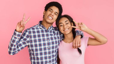 Arka plan üzerinde barış hareketi gösteren öğrenciler pembe