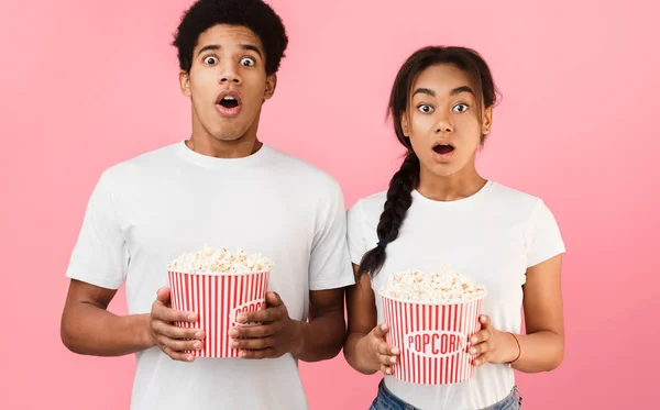 Una película aterradora. Pareja sorprendida sosteniendo cubo de palomitas de maíz —  Fotos de Stock