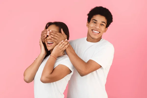 Cara cobrindo meninas olhos, fazendo surpresa para ela — Fotografia de Stock