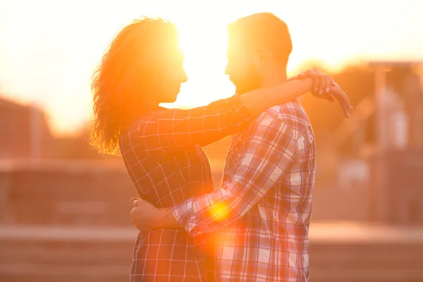 Casal de abraços, desfrutando de belo pôr do sol, na cidade — Fotografia de Stock