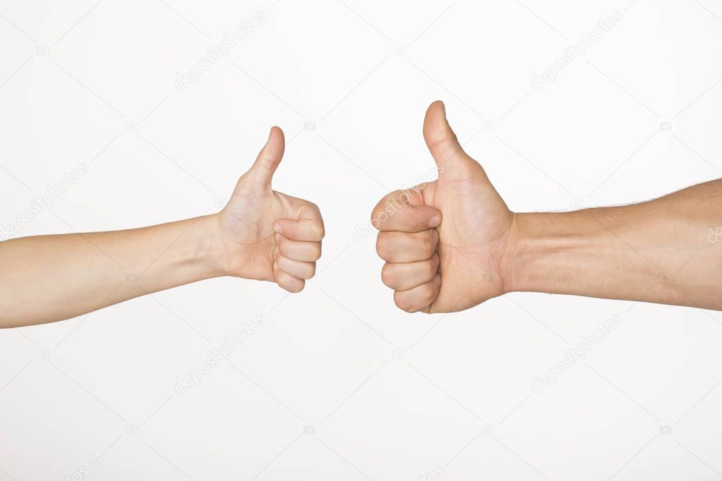 Hands of adult man and child showing thumb up gesture