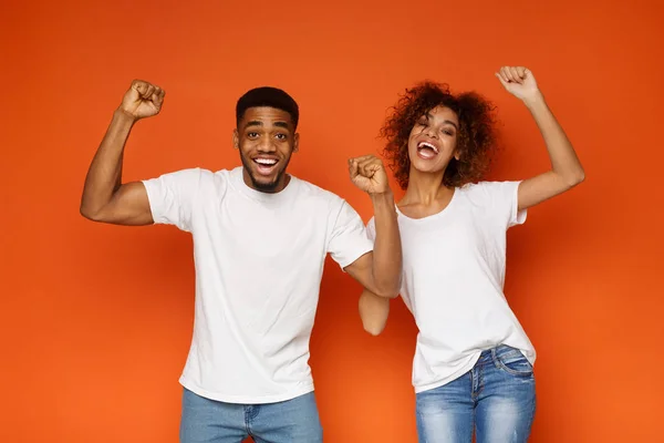 Happy emotional black man and woman enjoying success together