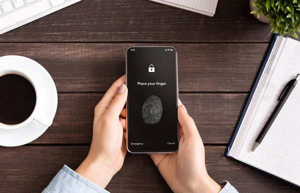 Mano sosteniendo el teléfono móvil con aplicación para escanear huellas dactilares — Foto de Stock