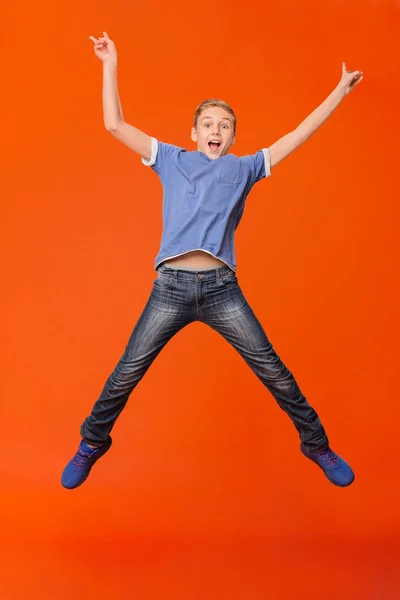 Happy boy jumping and raising his hands up — Stock Photo, Image