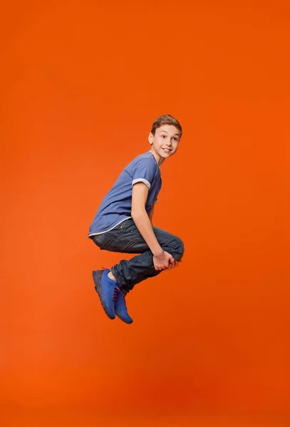 Emocional chico saltando en estilo bomba en naranja —  Fotos de Stock
