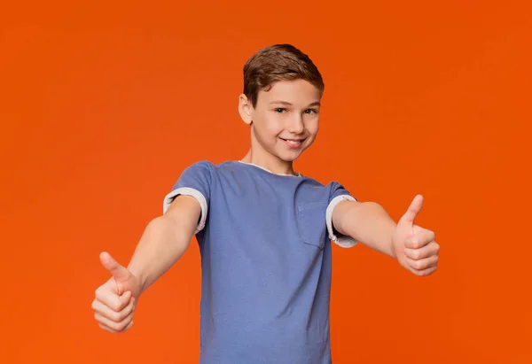 Cool kille gör tummen upp gest på orange — Stockfoto