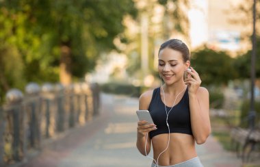 Kız müzik smartphone üzerinde çalıştırmak için seçin