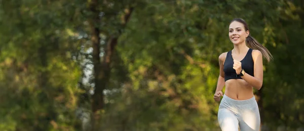 Active sportswoman running in empty morning park — Stock Photo, Image