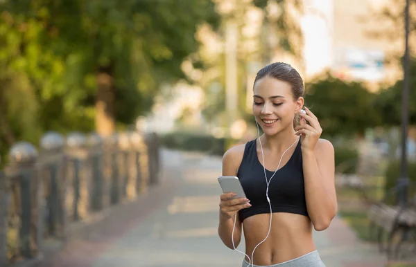 Chica elegir la música para correr en el teléfono inteligente — Foto de Stock