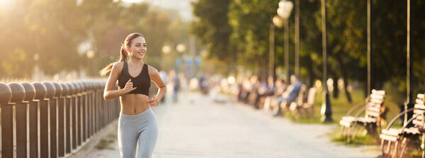 Pretty girl jogger training in city park