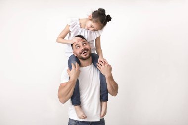 Sevimli küçük kızını omuzlarında taşıyan mutlu baba