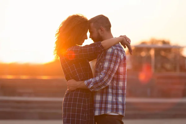 Milovaný pár všeobjímající a dotýká čela při západu slunce — Stock fotografie