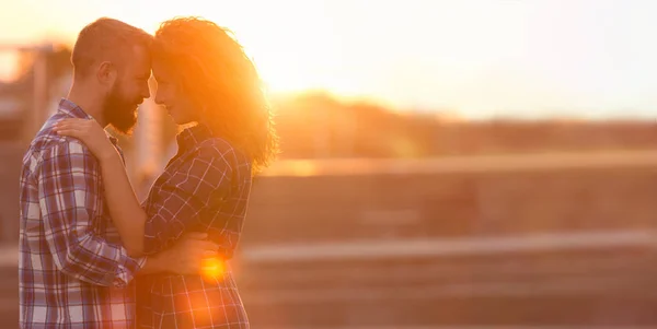 Pareja romántica tocando frentes contra la puesta de sol de la ciudad —  Fotos de Stock