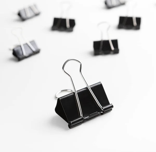 One binder clip standing out of others on white — Stock Photo, Image