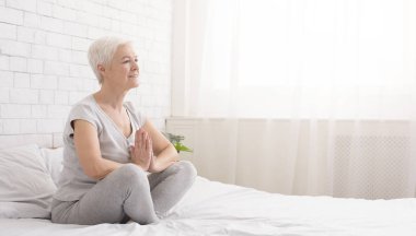 Beyaz kadın yatakta Yoga uygulamak