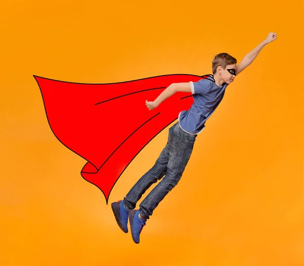 Мальчик в маске и красном плаще летят как герой — стоковое фото