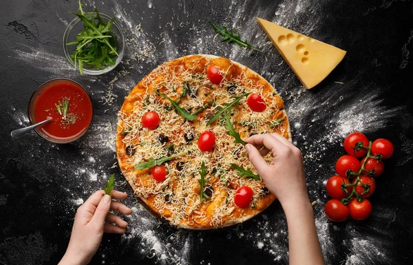 Chef dekoriert Pizza mit Rucola und Kirschtomaten — Stockfoto