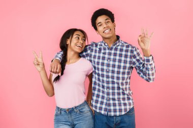 Pembe arka plan üzerinde gösterilen ok ve barış mutlu öğrenciler jest