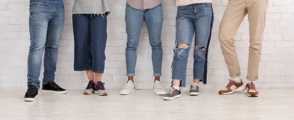 Ноги друзей. Молодые люди в джинсах и брюках — стоковое фото