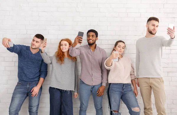 Młodzi ludzie robienia selfie na ich smartfonach — Zdjęcie stockowe