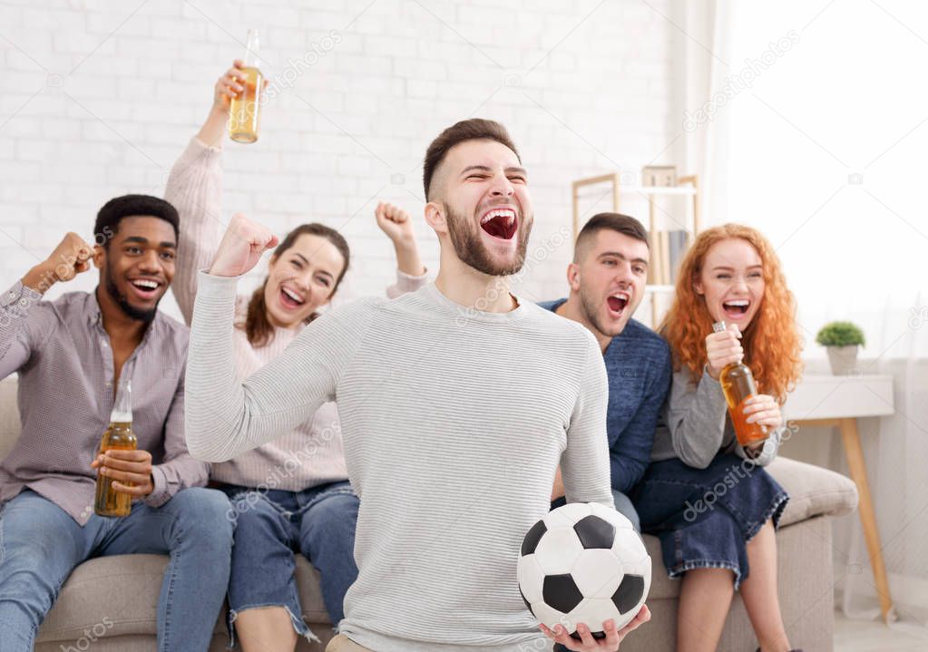 Happy football fans watching match on tv