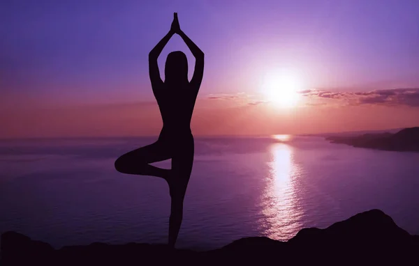 Frau praktiziert Yoga bei Sonnenuntergang. — Stockfoto
