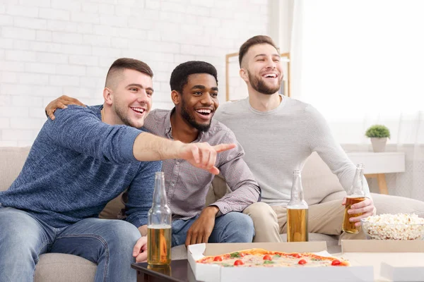 Guarda qua. Uomo che punta in tv, guardando il calcio con gli amici — Foto Stock