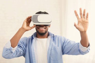 Gözlüklerini evde deneyen neşeli bir adam.