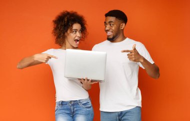 Neşeli milenyal siyah adam ve kadın laptop işaret