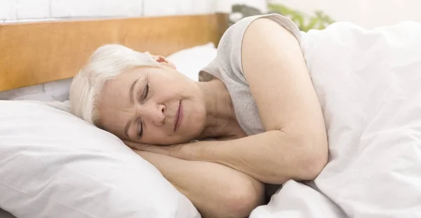 Senior mulher dormindo na cama de manhã — Fotografia de Stock