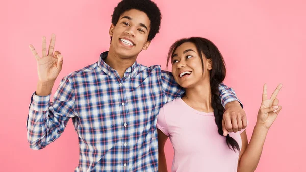 Tieners tonen OK en vrede gebaar over roze achtergrond — Stockfoto