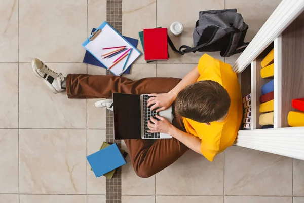 Студент, обучающийся с ноутбуком в библиотеке, вид сверху — стоковое фото